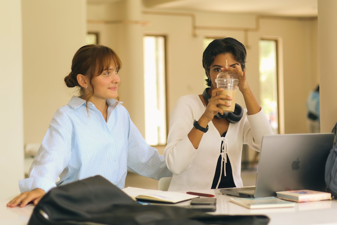 Two students comparing notes and talking through an assignment together