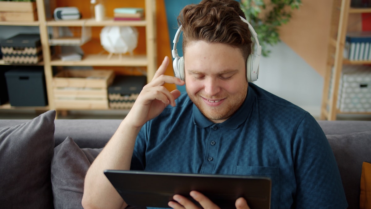 A student speaks aloud while looking at a tablet on a classroom desk