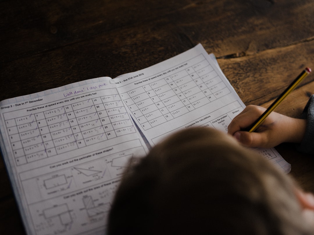 Student writing out a math problem in a notebook